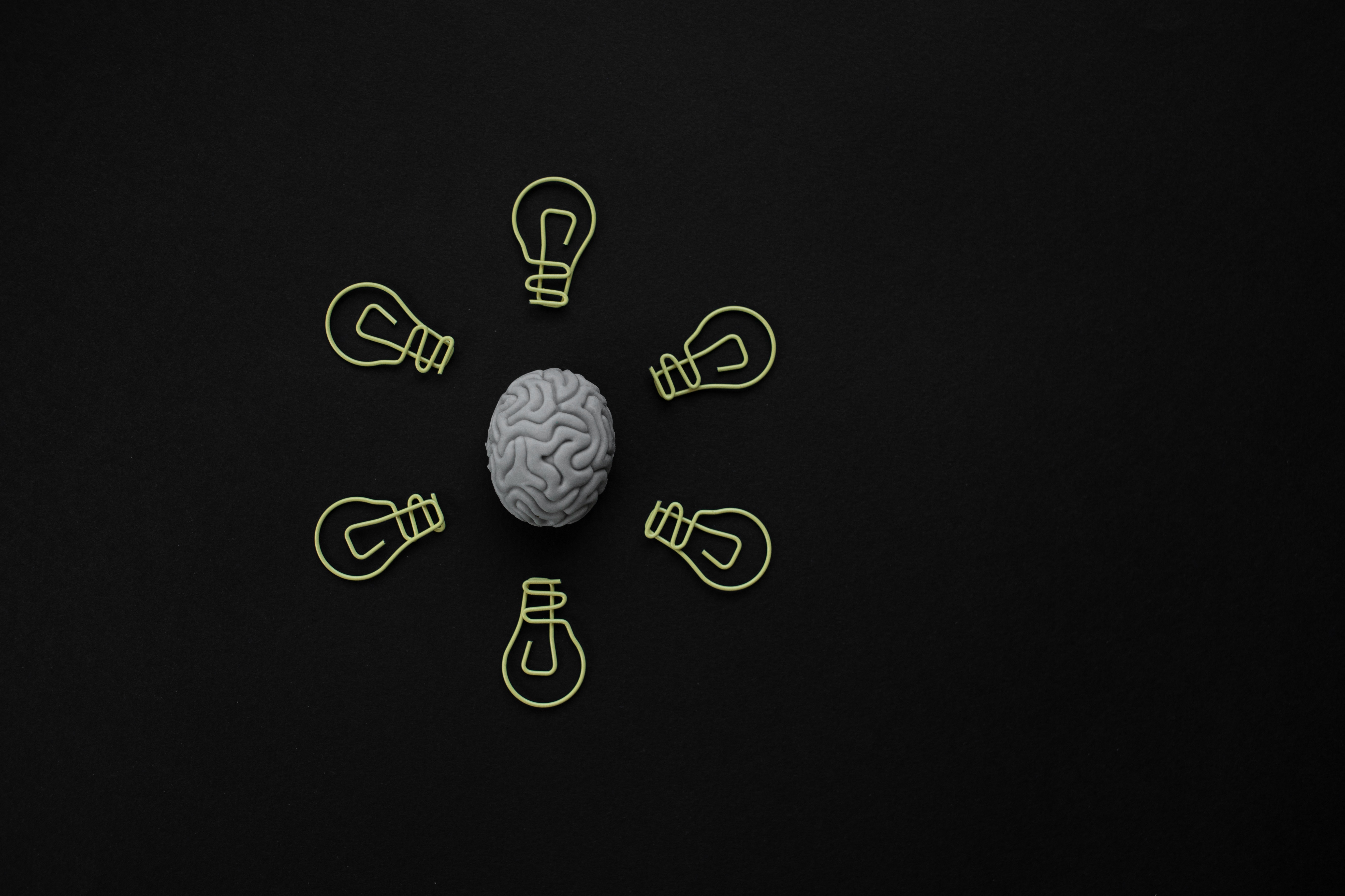 Human brain with 6 light bulbs around it.