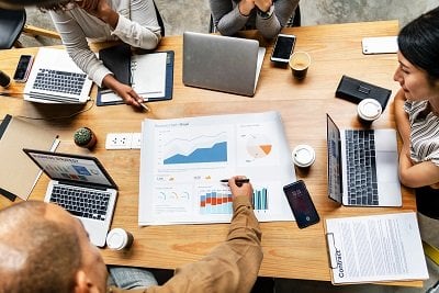 Image of people sitting around a table looking at charts