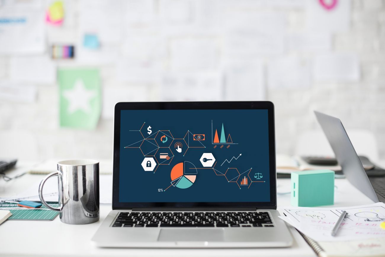 Image of a laptop and mug of coffee and messy desk