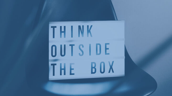 Lightbox sign on a chair that reads “THINK OUTSIDE THE BOX.”
