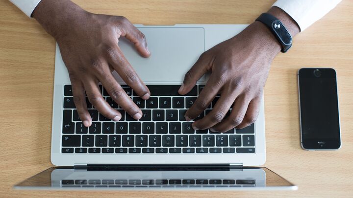 Person typing on a laptop keyboard