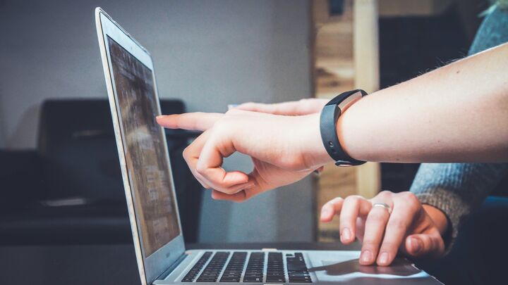two hands pointing at a laptop