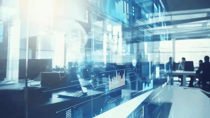 A futuristic office space with translucent digital data overlays—including bar charts, graphs, and network diagrams—floating in the foreground, while silhouettes of workers sit at desks in a bright, modern background.