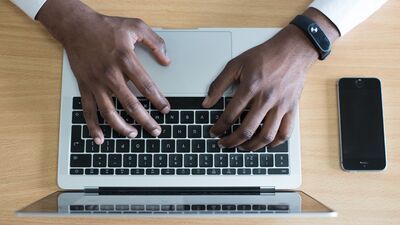 Person typing on a laptop keyboard