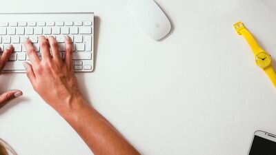 hands on keyboard on desk