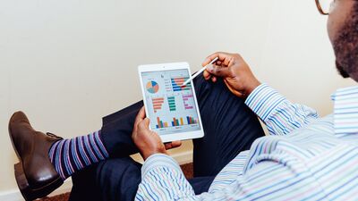 man looking at tablet with graphs