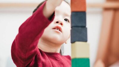 A child stacking toy blocks.