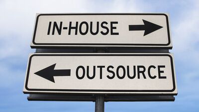 Road sign showing in-house and outsource.