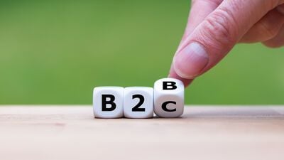 Hand turns a dice and changes the expression "B2B" to "B2C"