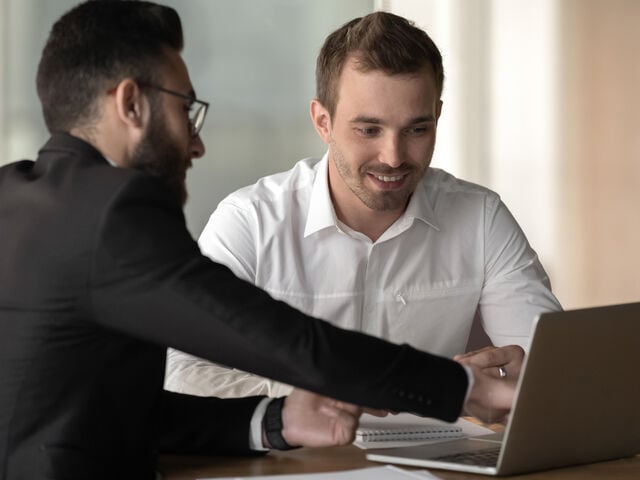 Two People Talking in Front of Laptop