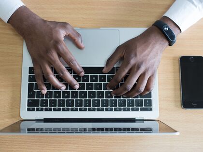 Person typing on a laptop keyboard