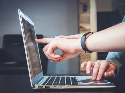 two hands pointing at a laptop