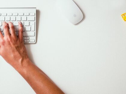 hands on keyboard on desk