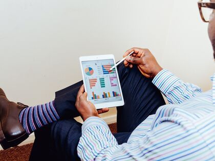 man looking at tablet with graphs