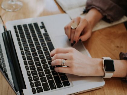 hands typing on laptop keyboard