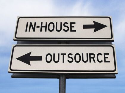 Road sign showing in-house and outsource.