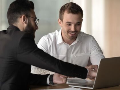 Two People Talking in Front of Laptop