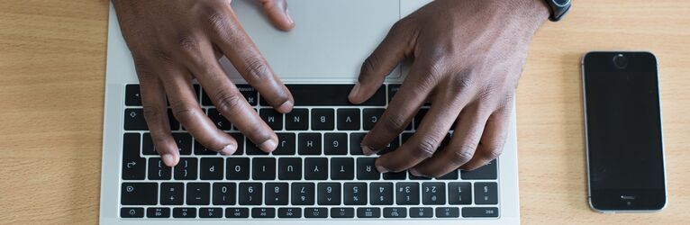 Person typing on a laptop keyboard
