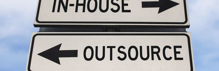 Road sign showing in-house and outsource. 