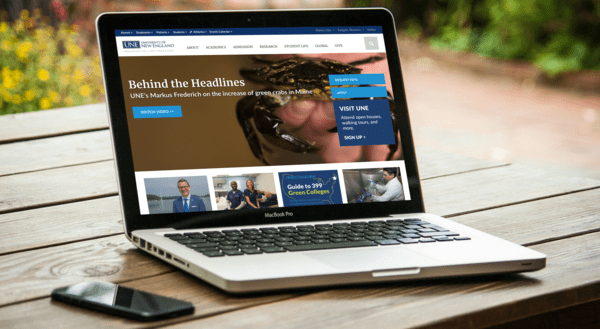 UNE website displayed on a laptop computer