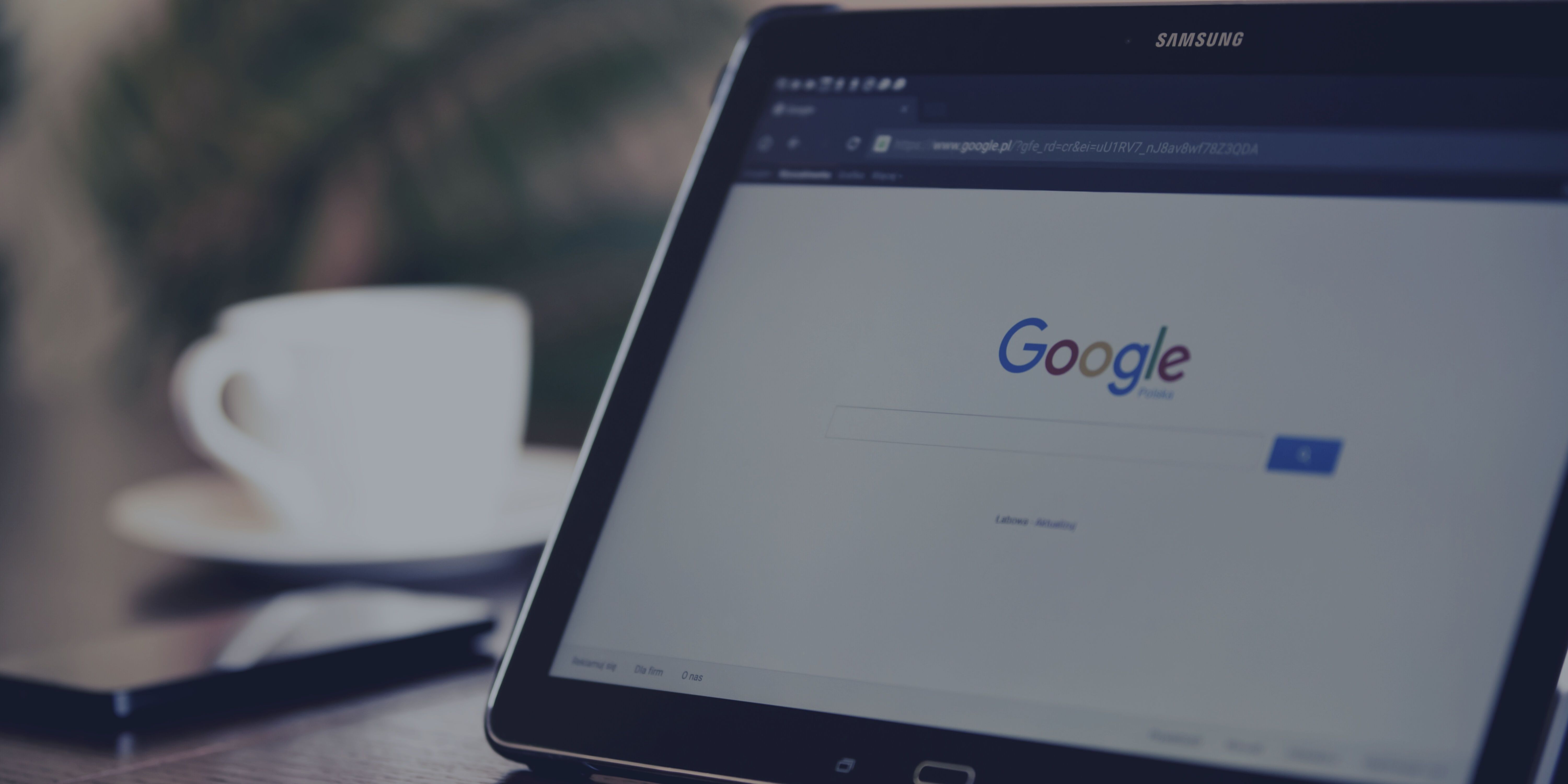 Image of a laptop with the Google homepage on the screen and a cup of coffee in the background