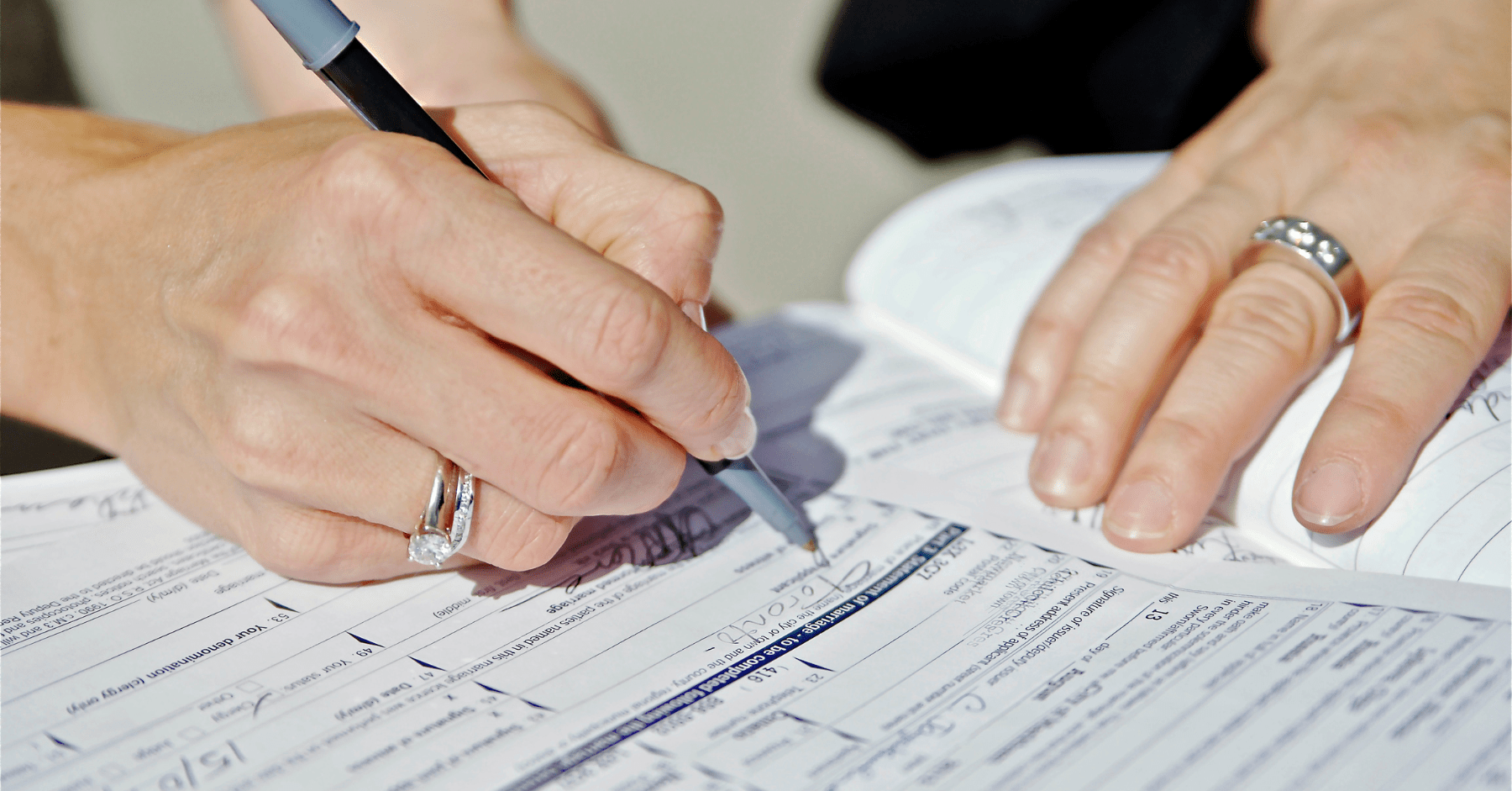 A person filling out a form. 