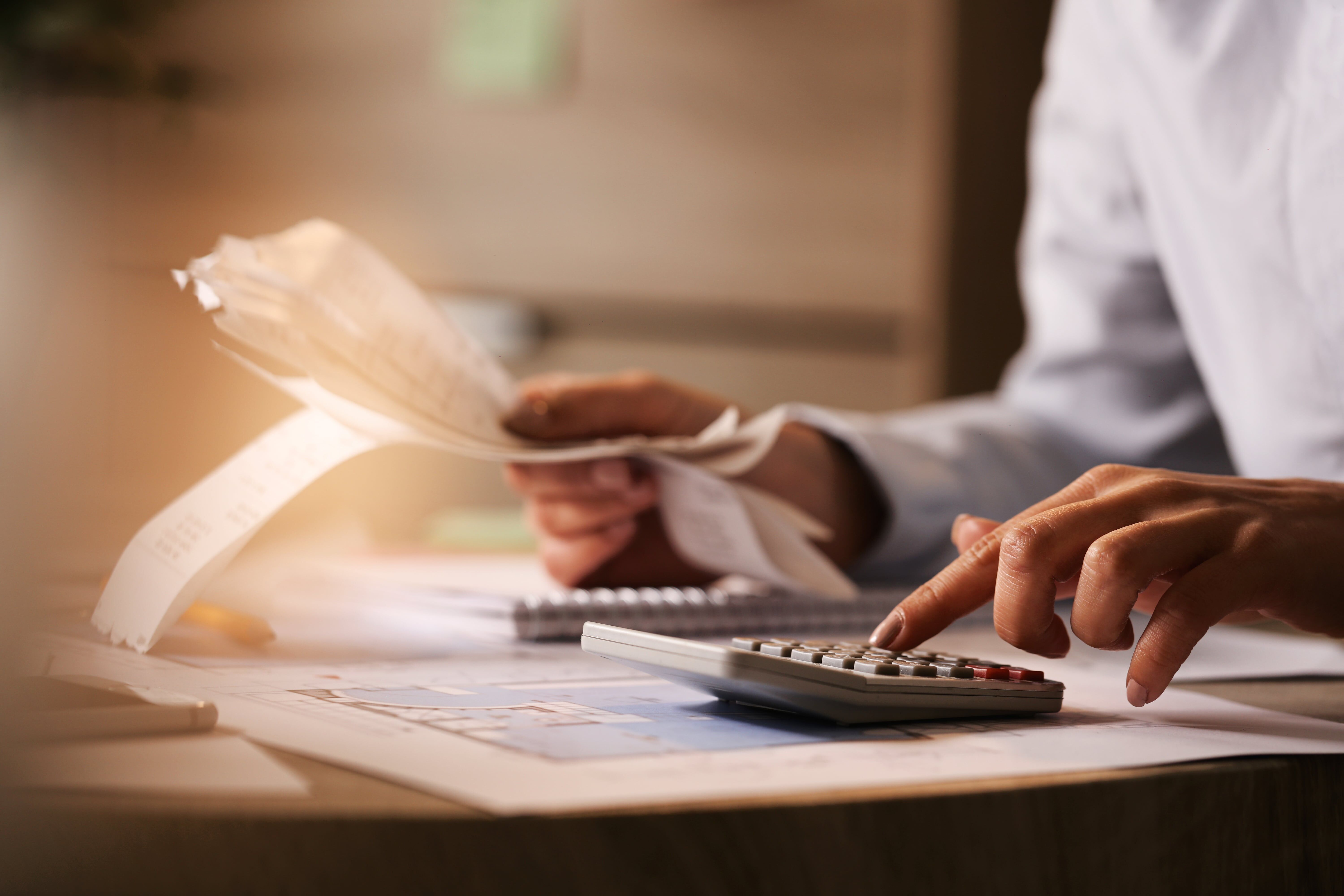 A person using a calculator to check prices
