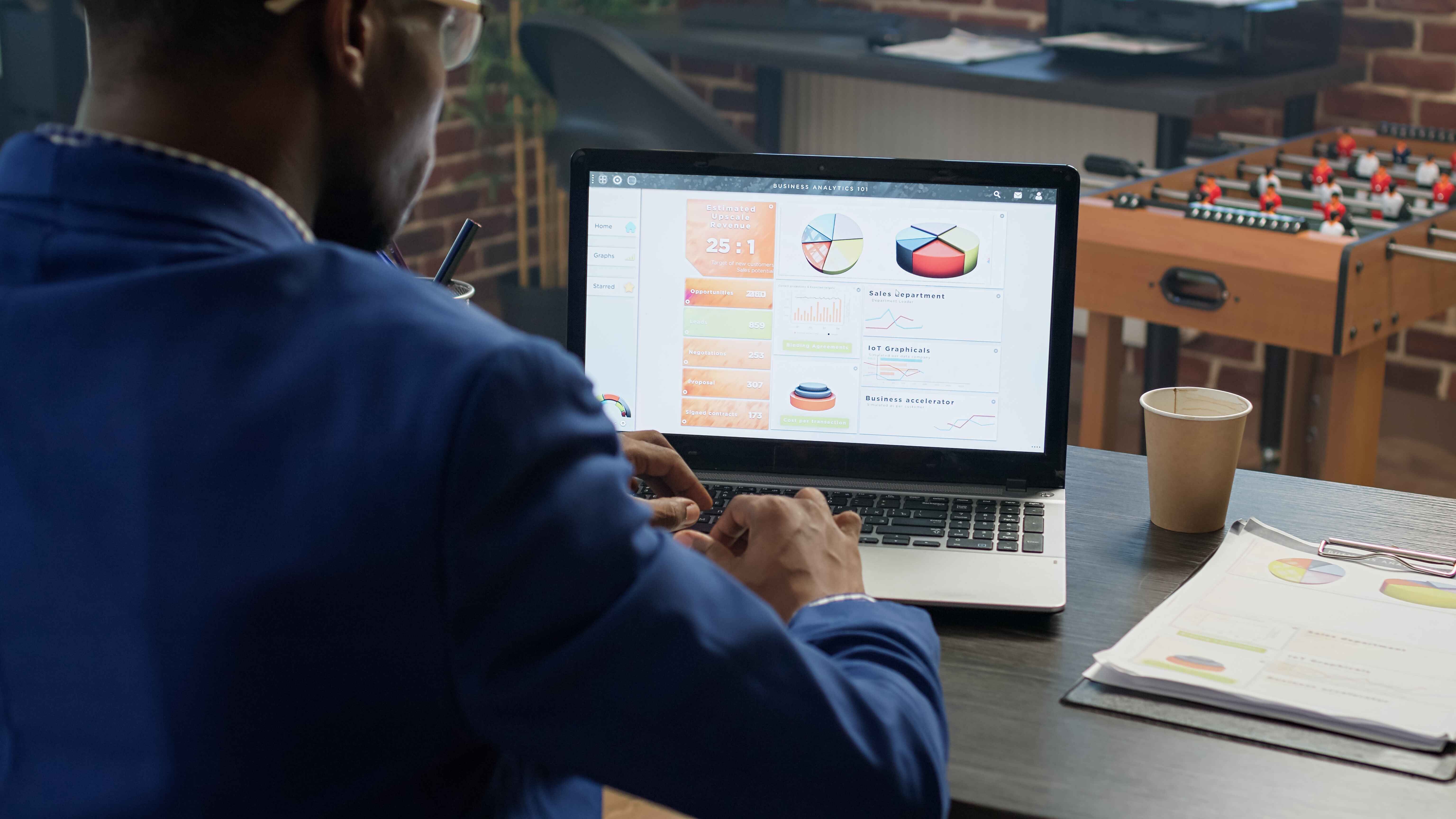 Digital marketer analyzing graphs and charts on a laptop screen