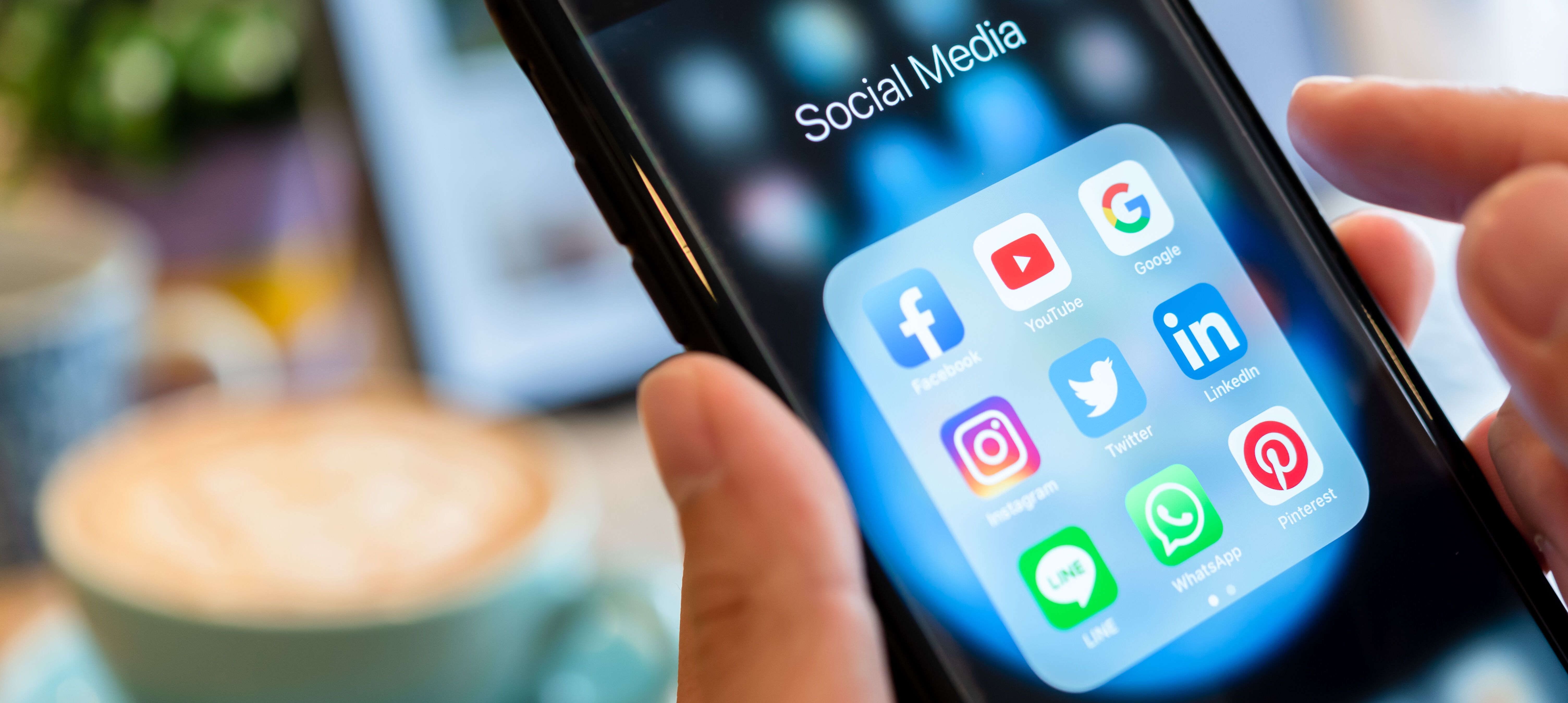 Hands of man use Iphone 7 plus with social media application of facebook, youtube, google search, instagram, twitter, linked in, line whatsapp, and pinterest on black background