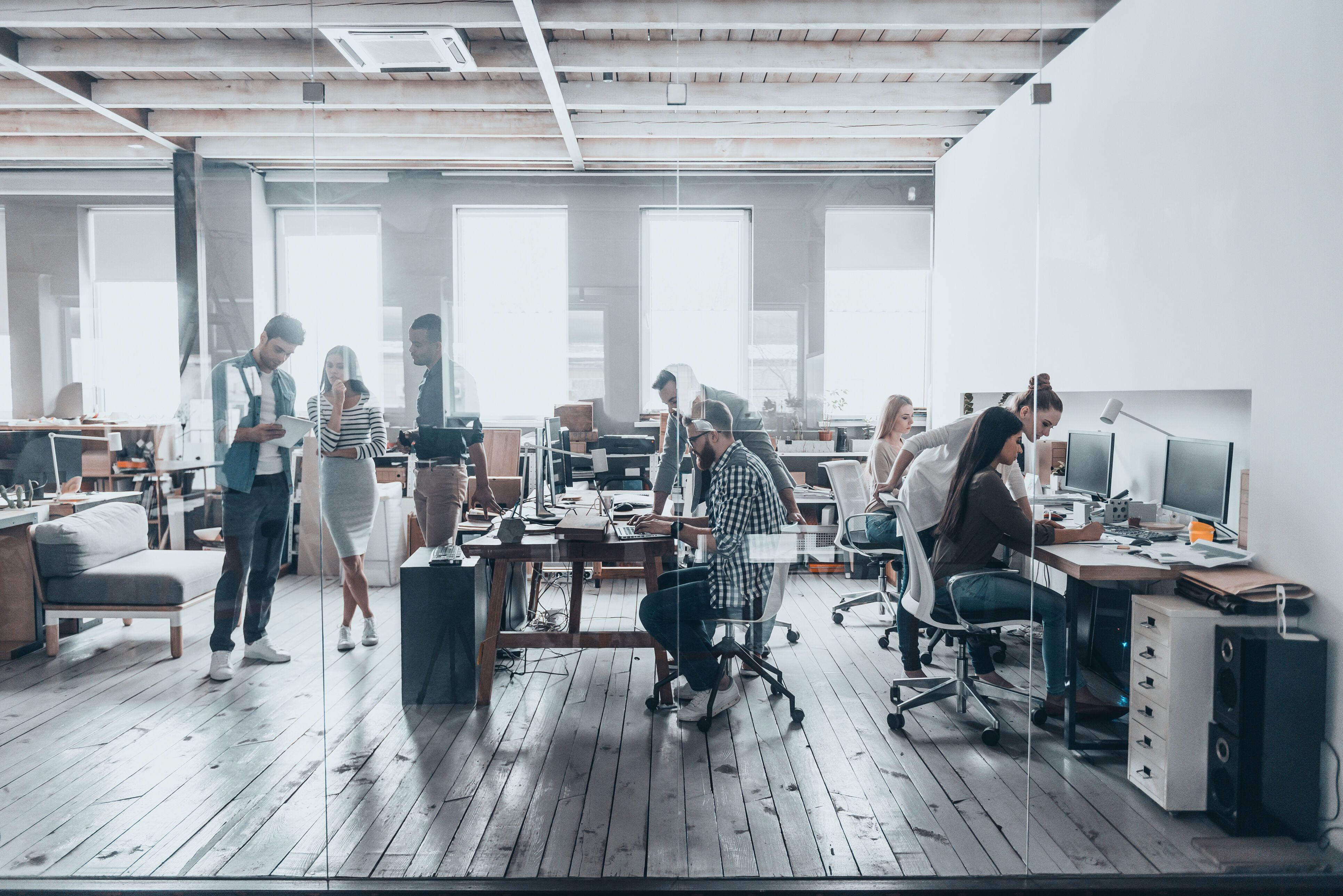 Group of young business people in smart casual wear working together in creative office