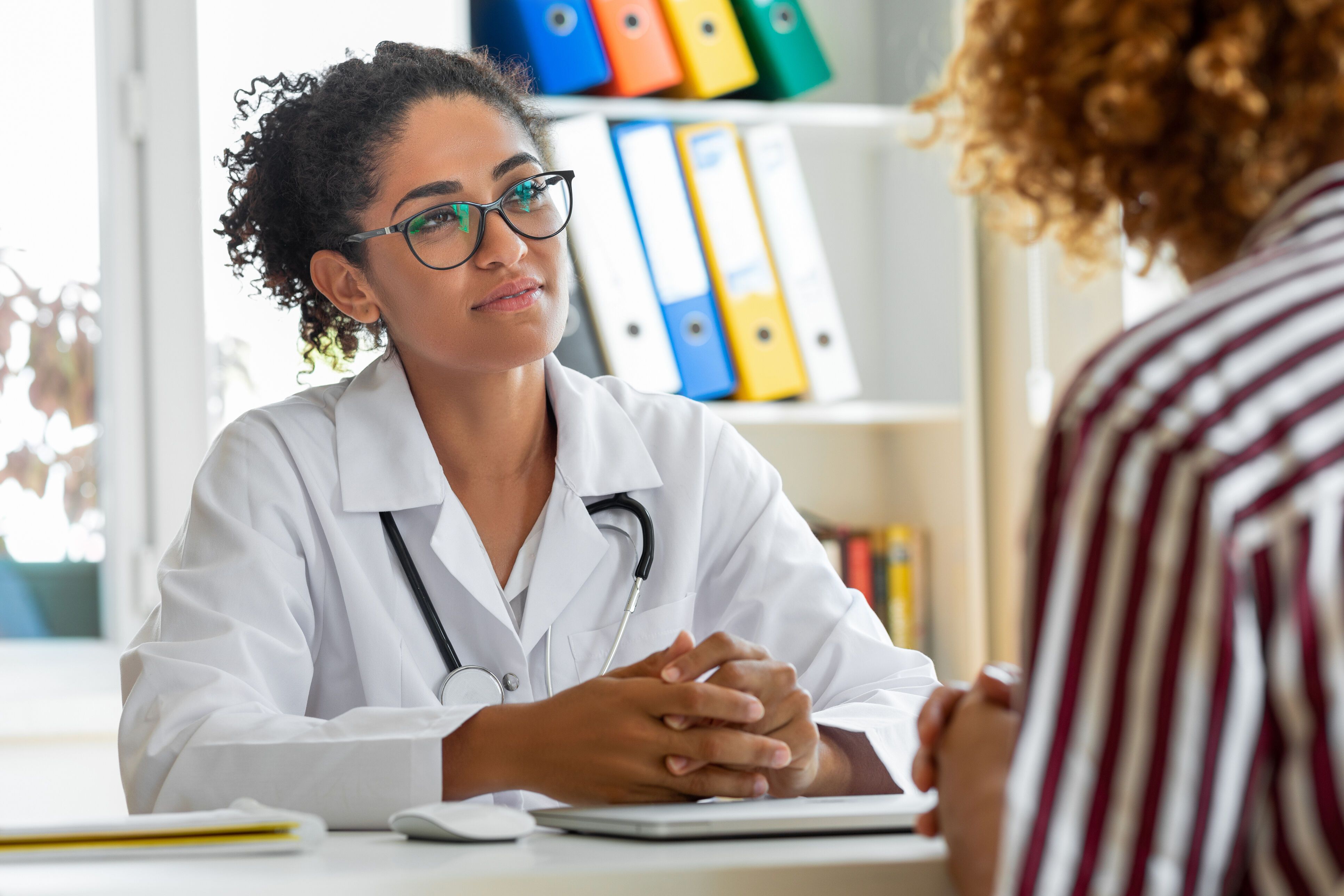 Female patient speaking with her pediatrician in a doctors office