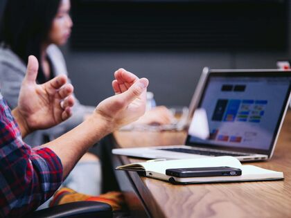 Employee making a hand gesture in a team meeting